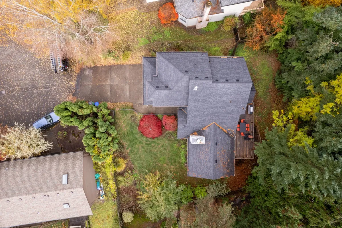 A welcoming exterior view of the cottage and its beautifully landscaped yard, dotted with colorful autumn trees. The peaceful setting suggests ample space for pets to enjoy a stroll or play while providing a sense of connection to nature.