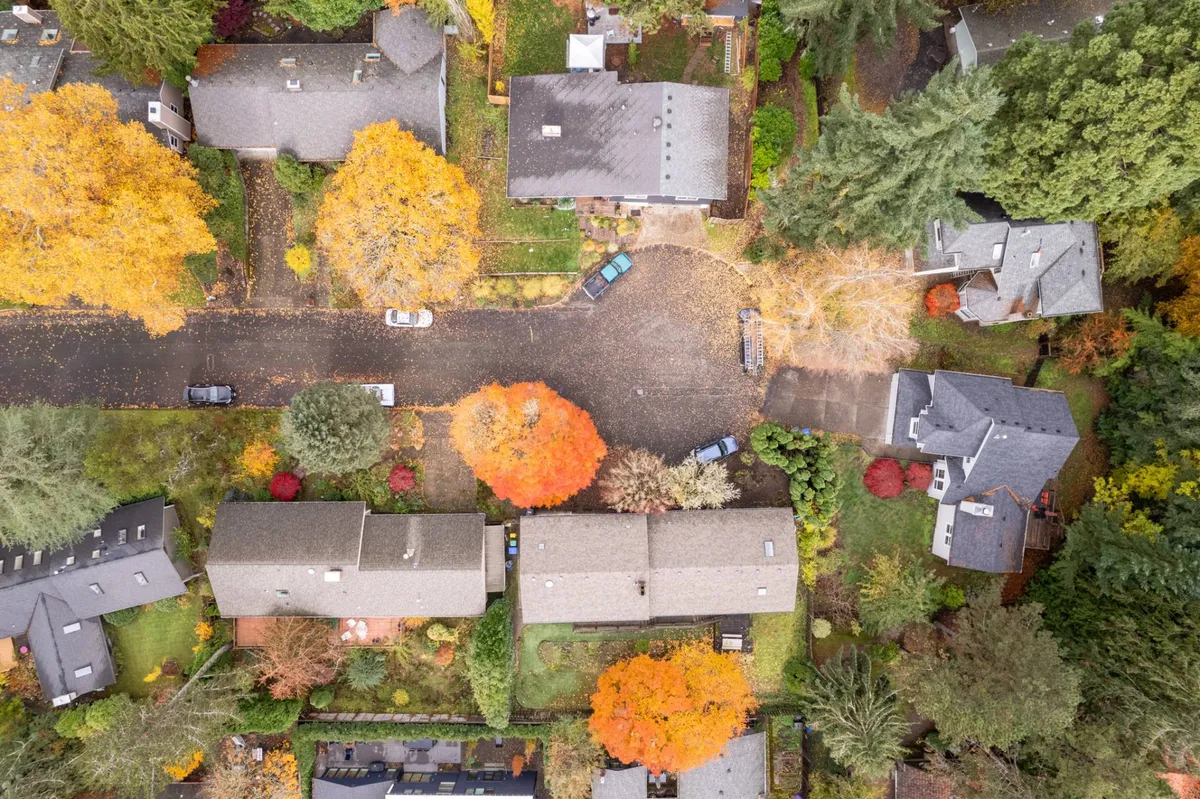 A tranquil neighborhood view featuring colorful autumn trees, neat residential homes, and a cul-de-sac layout. The area looks ideal for family walks, play, and quiet outdoor activities, reflecting a safe and welcoming community setting.