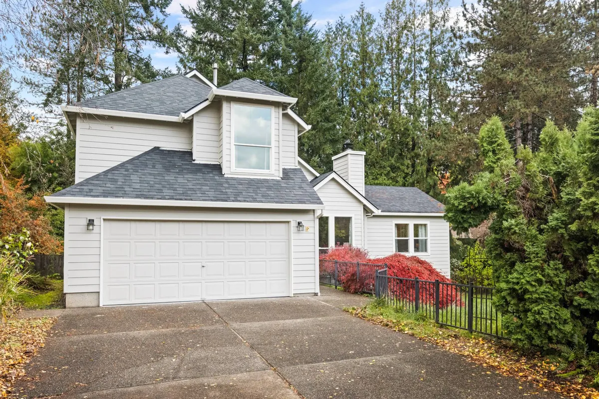 This image shows the exterior of Bridlemile Cottage, highlighting its two-story structure, prominent garage door, and landscaped front yard. The image conveys a welcoming, inviting atmosphere and underscores the physical presence of the garage—central to the section's focus.
